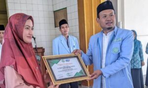 Ketua BKPRMI Lutra, Amiruddin, saat memberikan penghargaan kepada Bupati Indah Putri Indriani di Sukamaju